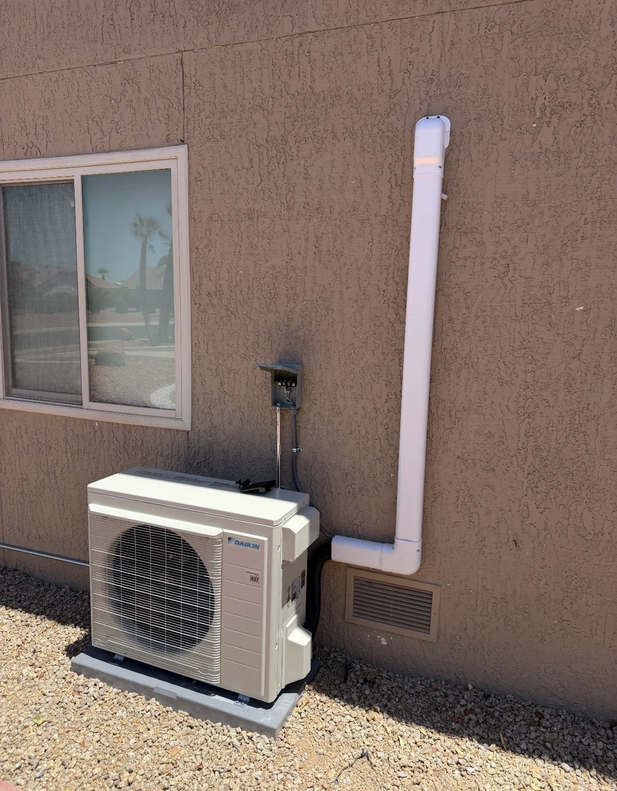 Outdoor mini-split condenser with refrigerant line routing